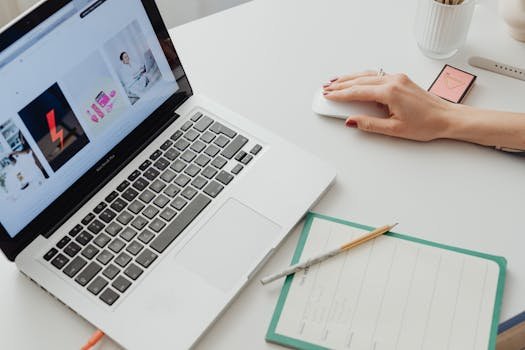 Close-up of a workspace featuring a laptop, mouse, and notepad for productive work.