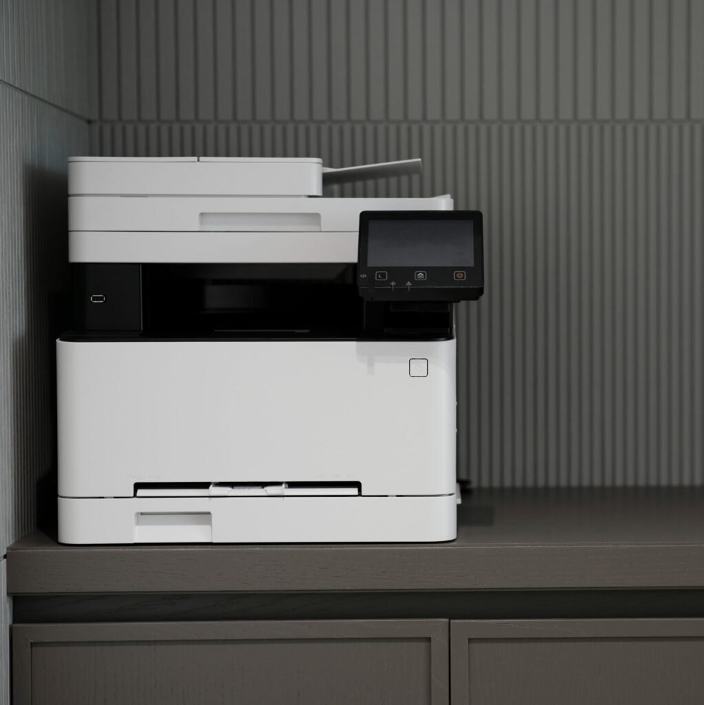 A sleek, modern printer situated on a minimalist office desk with a textured background.