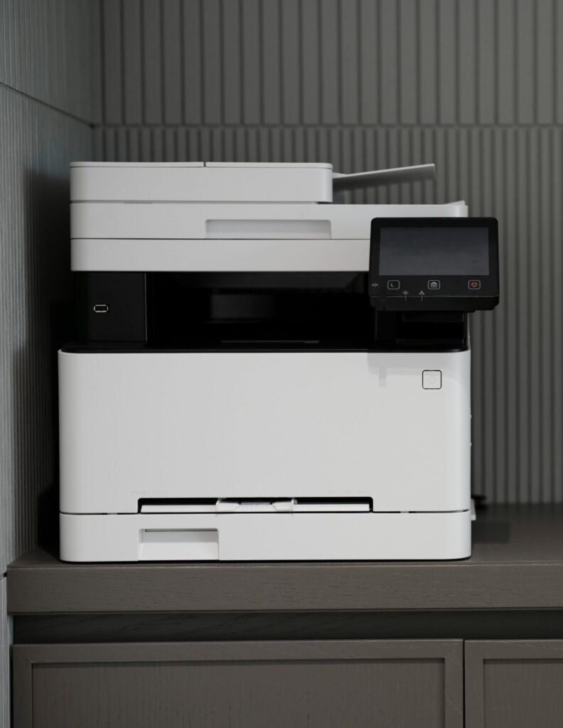 A sleek, modern printer situated on a minimalist office desk with a textured background.